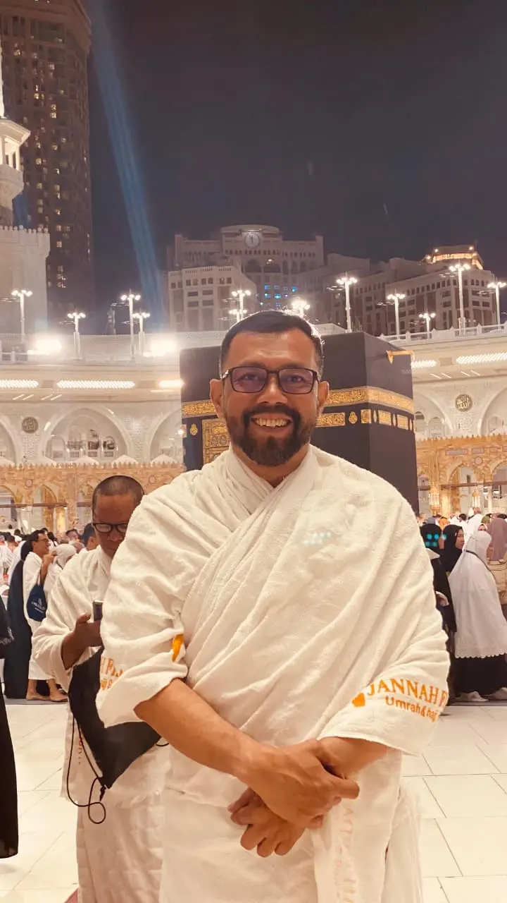 Kelompok jamaah umroh Jannah Firdaus Travel sedang berdoa bersama di Masjidil Haram dengan latar belakang Ka'bah yang megah